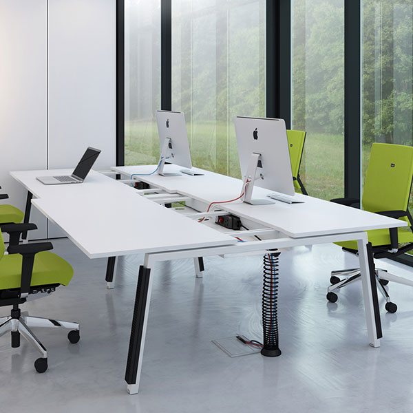 A photo of modern bench style office desks with integrated cable management