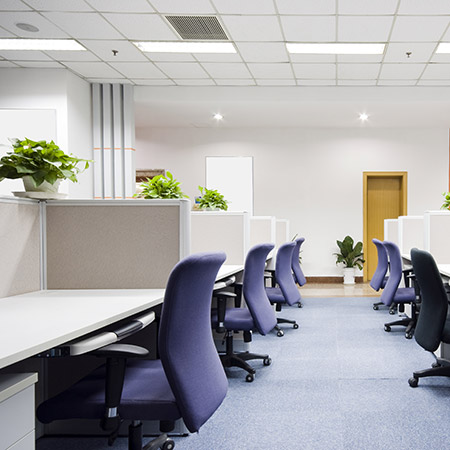 Photo of modern office with rows of workstations