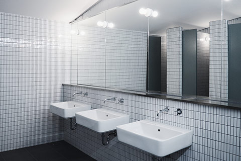 A photo of a modern office washroom with shiny blue surfaces